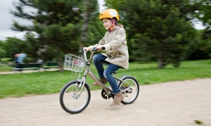 A young girl rides one of the P'tit Velib bicycles